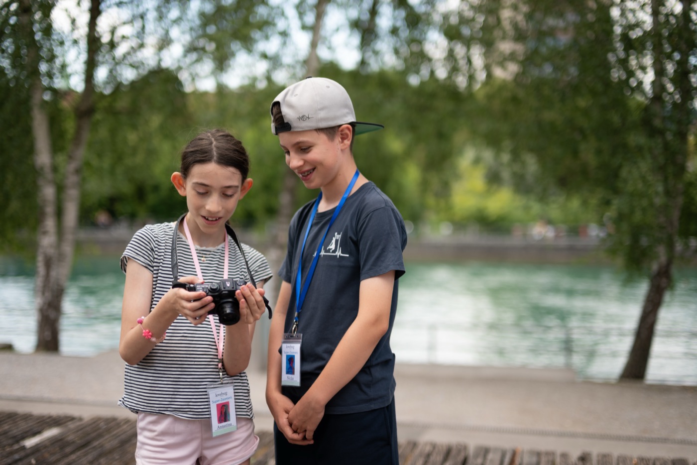 Zwei Kinder schauen gemeinsam auf eine Kamera an der Limmat